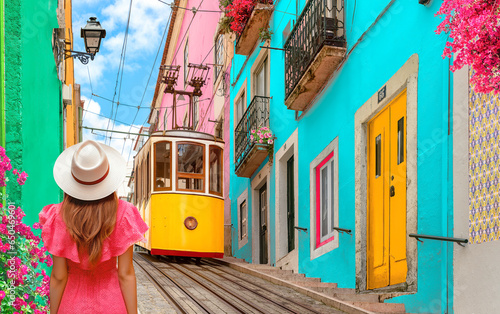 Yellow tram, Lisbon, Portugal - Young Traveler woman wearing red dress and hat visit Lisboa colorful houses in old town - Travel wanderlust concept