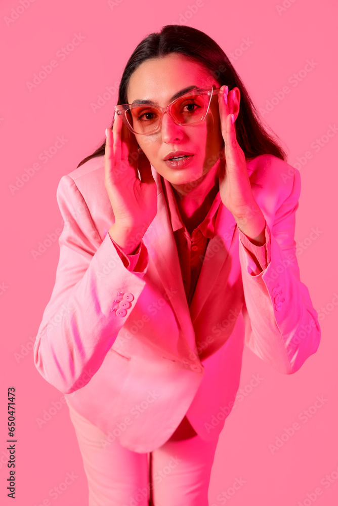 Young woman in stylish suit on pink background Young woman in stylish suit on pink background