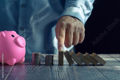 Economic collapse concept, hands stop domino crisis effect, financial and banking problems, recession, financial crisis, bad debt, inflation and interest rates, asset safety