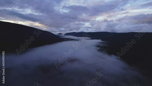 Dramatic cloudscape in blue hour, drone moving above fog. Norway photo