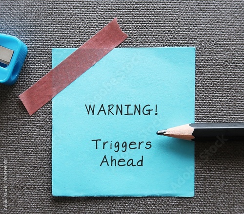 Valokuva Blue stick note with handwritten text WARNING! triggers ahead - concept of knowi