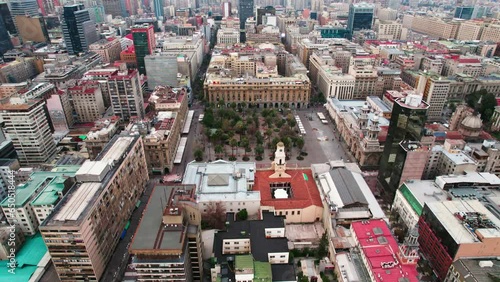 Aerial orbit establishing of the Plaza de Armas of Santiago, center of the capital of Chile, morning with soft light, garden in the middle of the city.