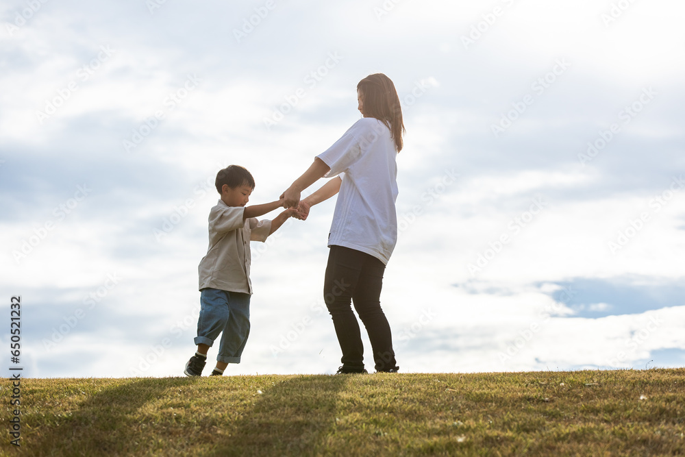 丘の上で手を繋ぐ親子　Parent and child holding hands