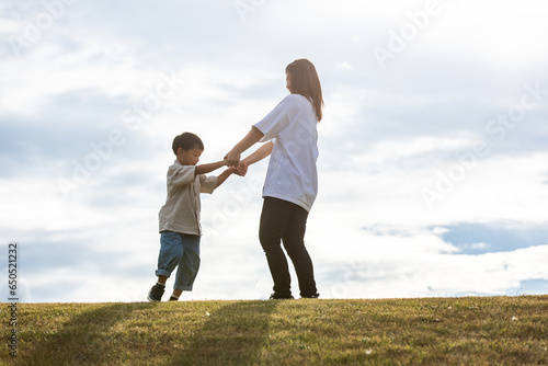 丘の上で手を繋ぐ親子 Parent and child holding hands