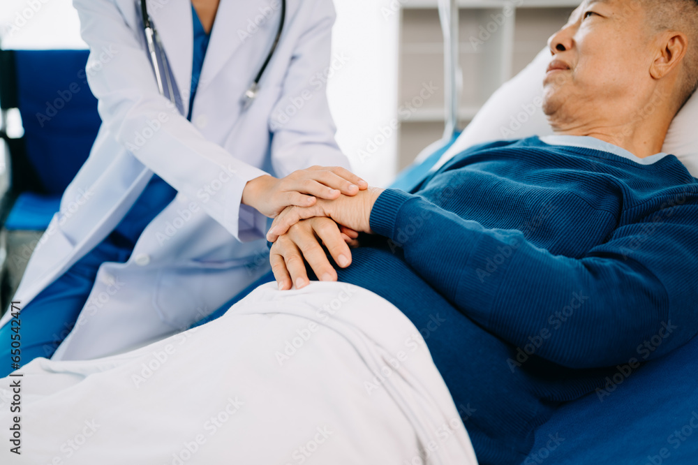 Obraz premium Female doctor holding male patient hand on the bed with receiving saline solution in hospital.