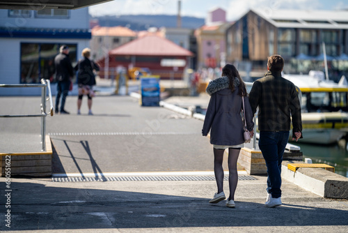 couple walking holding hands on a wharf in hobart