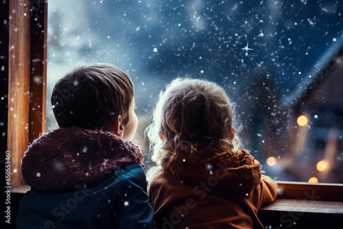 children watching snow from window 
