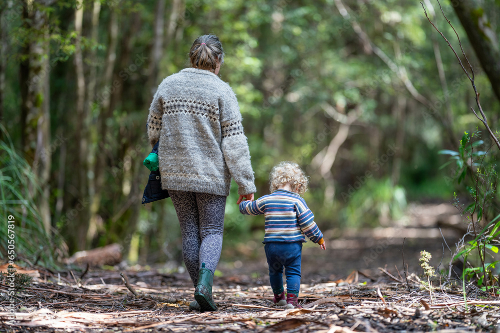 Mother with baby in a carrier on her chest on a hike, taking a bush walk in Summer in a national park in Sydney, nsw, Australia Mother with baby in a carrier on her chest on a hike, taking a bush walk in Summer in a national park in Sydney, nsw, Australia