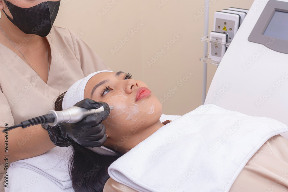 Using an RF electromagnetic device for radiofrequency skin tightening or contouring treatment. At a facial care, dermatologist or aesthetic clinic.