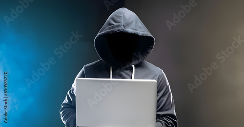 Hacker in front of his computer, dark face.