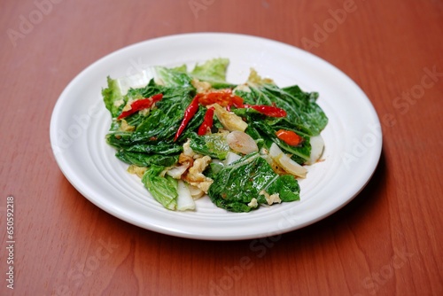 Stir fry Chinese cabbage, stir fry Napa cabbage, tumis sawi putih served on white plate on isolated background. Stir fried Chinese cabbage, stir fried Napa cabbage