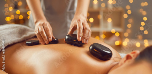 Photography Woman relaxing in spa salon with hot stones along spine
