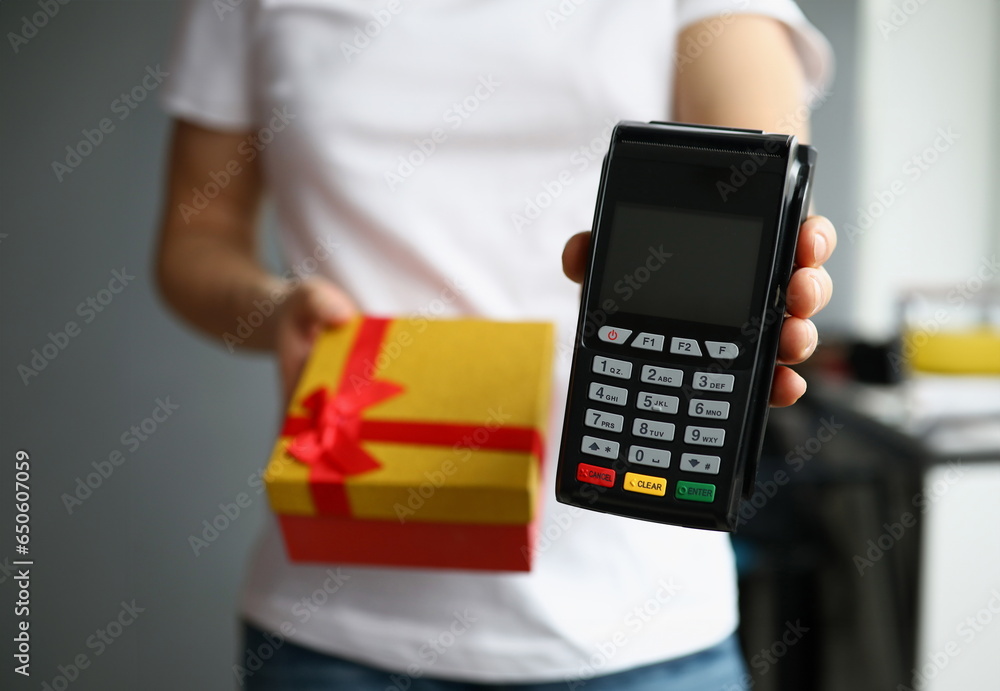 Courier is holding gift box and payment terminal. Sending gifts for loved ones via courier service concept Courier is holding gift box and payment terminal. Sending gifts for loved ones via courier service concept