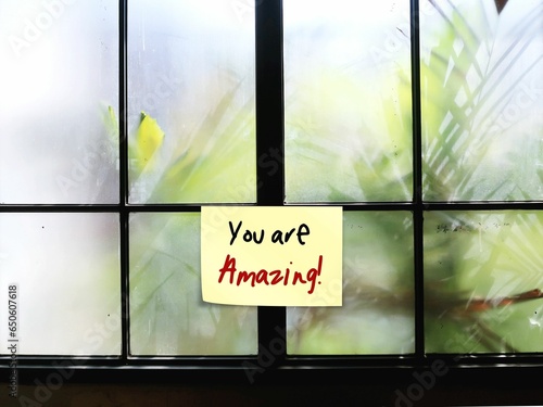 Note stick on window with handwritten text YOU ARE AMAZING, nice compliment thing to say to someone to tell they are wonderful, unbelievable, brilliant and special or doing a great job