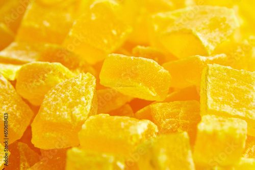 Diced mango dried fruits texture background. Dehydrated mango chips dices, sweet food closeup. The softness of dehydrated mango against the candied coating offers a delightful contrast.
