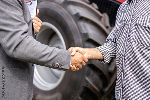 Investing in agricultural machines. Handshake and buying new tractor.