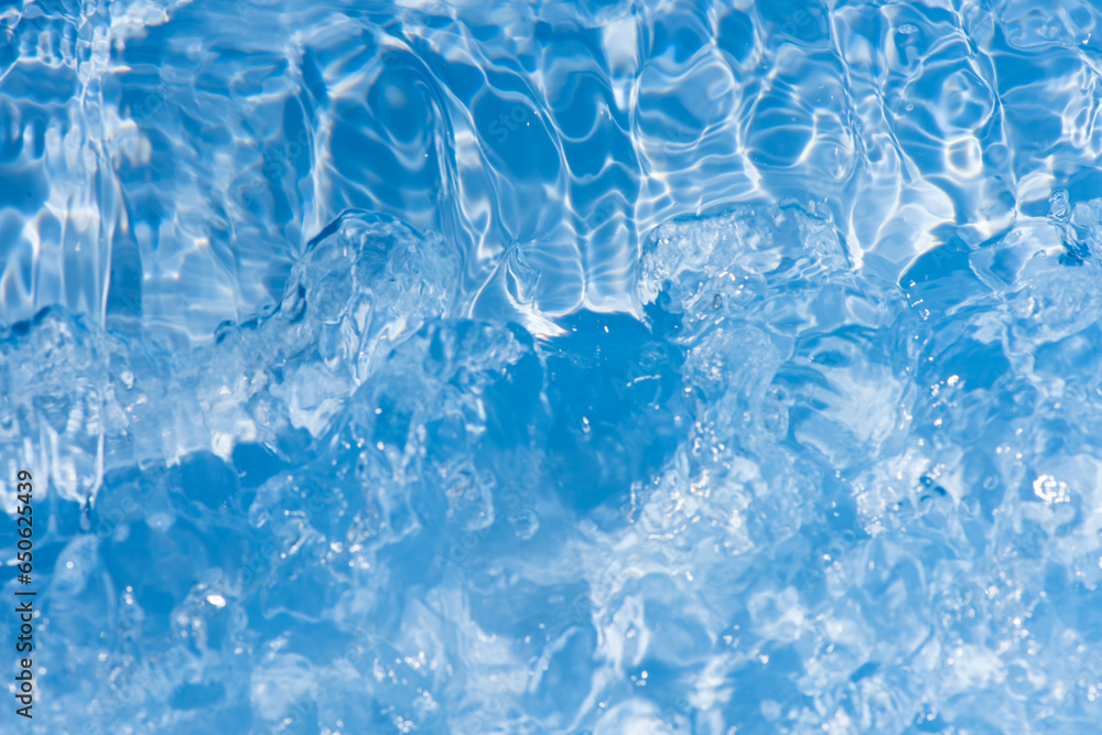 Defocus blurred transparent blue colored clear calm water surface texture with splashes reflection. Trendy abstract nature background. Water waves in sunlight with copy space. Blue watercolor shine. Defocus blurred transparent blue colored clear calm water surface texture with splashes reflection. Trendy abstract nature background. Water waves in sunlight with copy space. Blue watercolor shine.