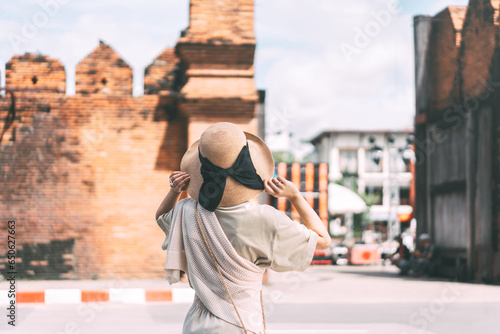 Tableau sur toile Rear view of standing tourist young adult asian woman with hat at Tha Phae Gate,