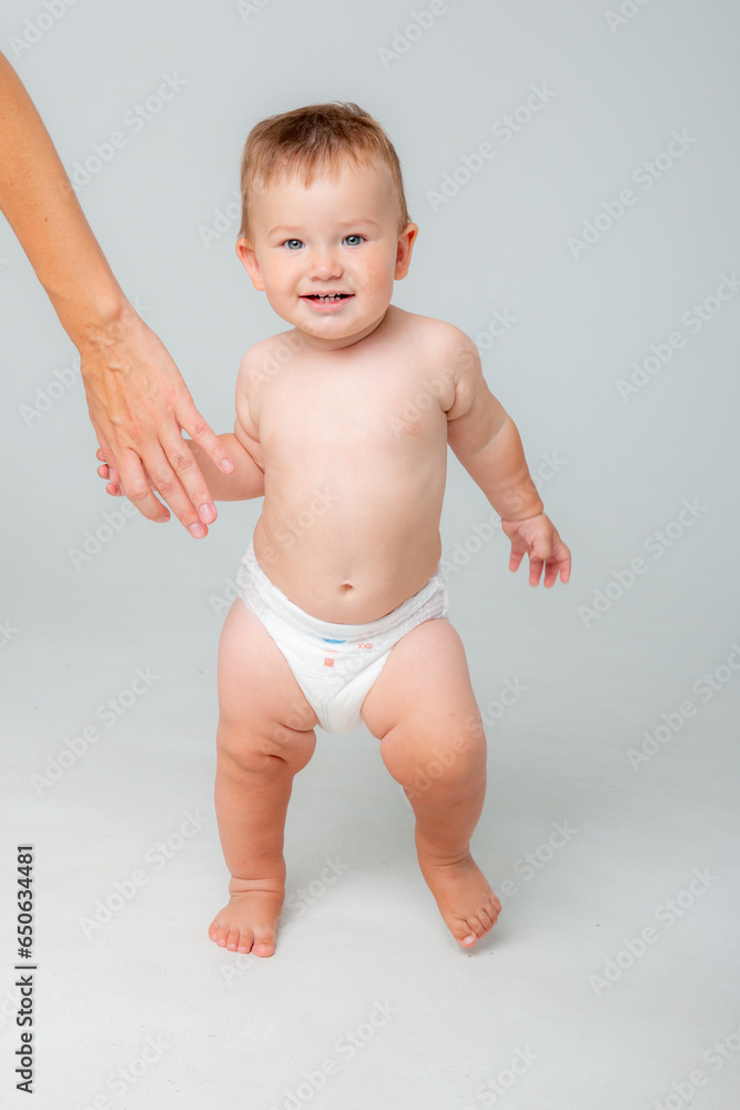 Smiling happy baby . Portrait of a little toddler boy, a baby in a diaper happily stands and laughs in isolation against the white background of the studio. The concept of childhood, motherhood, life, Smiling happy baby . Portrait of a little toddler boy, a baby in a diaper happily stands and laughs in isolation against the white background of the studio. The concept of childhood, motherhood, life,