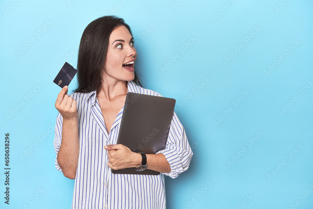 Professional with laptop and credit card on blue Professional with laptop and credit card on blue