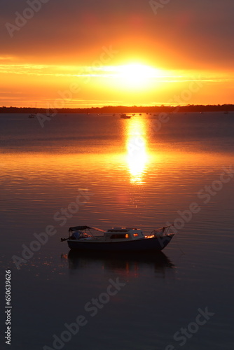 A Small Boat and its Reflection in the Sea with Sunrise in the Background, Tin Can Bay