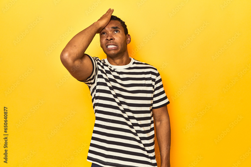 African American man in striped t-shirt, yellow studio, forgetting something, slapping forehead with palm and closing eyes. African American man in striped t-shirt, yellow studio, forgetting something, slapping forehead with palm and closing eyes.