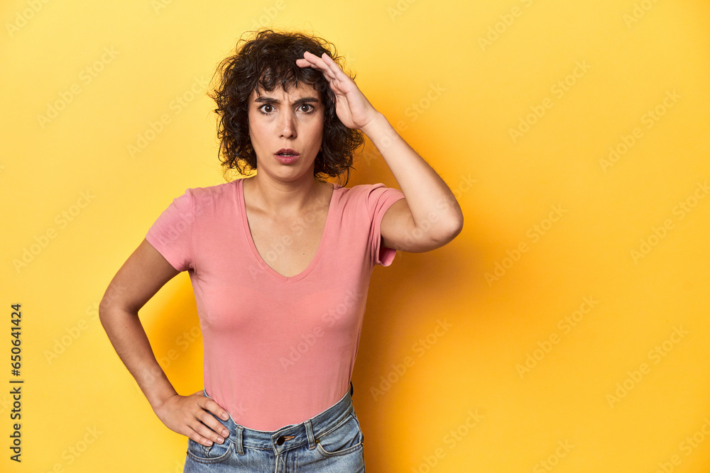 Curly-haired Caucasian woman in pink t-shirt shouts loud, keeps eyes opened and hands tense. Curly-haired Caucasian woman in pink t-shirt shouts loud, keeps eyes opened and hands tense.