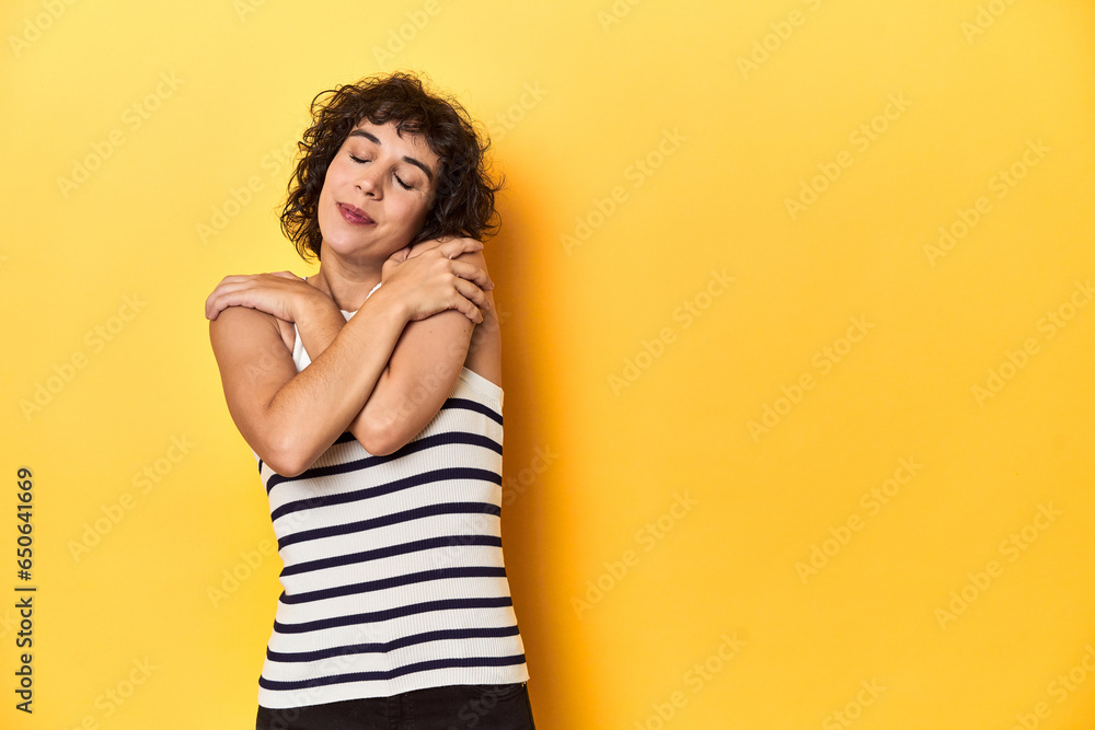 Caucasian curly-haired woman in white tank-top hugs, smiling carefree and happy. Caucasian curly-haired woman in white tank-top hugs, smiling carefree and happy.