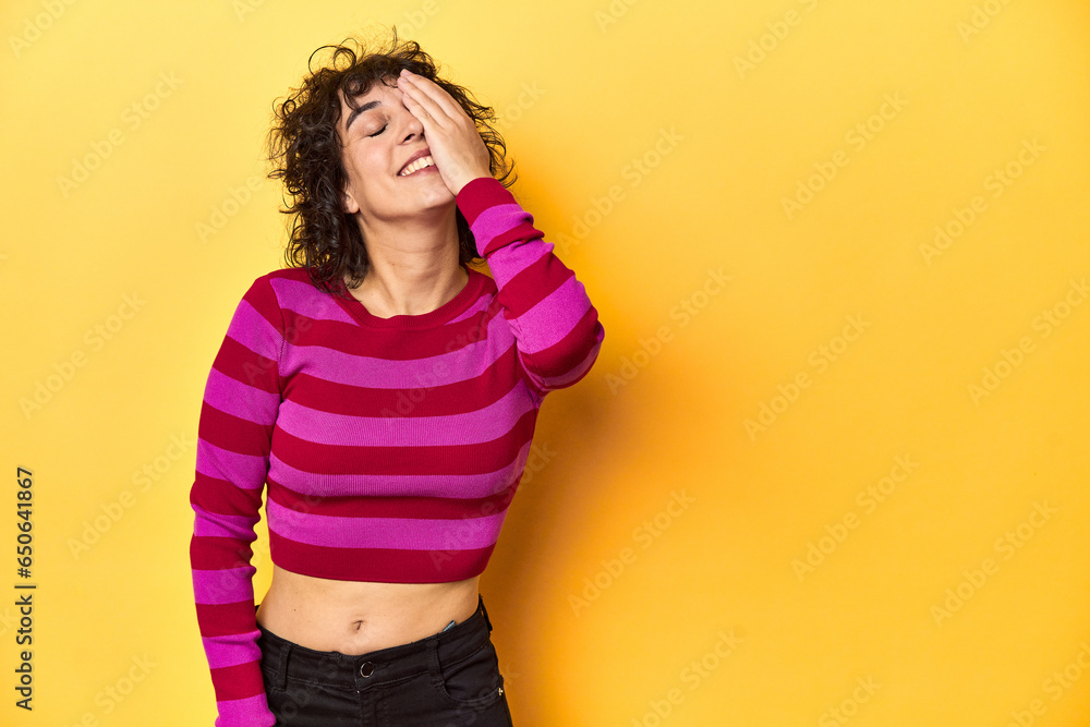 Caucasian curly-haired woman in pink striped-top laughing happy, carefree, natural emotion. Caucasian curly-haired woman in pink striped-top laughing happy, carefree, natural emotion.