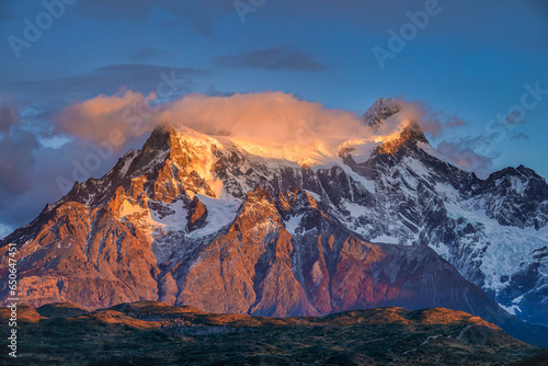 Beautiful mountain view of Paine Grande during sunrise and sunlight shines at mountain peak with clouds during autumn at Torres del Paine National Park, Patagonia in Chile.