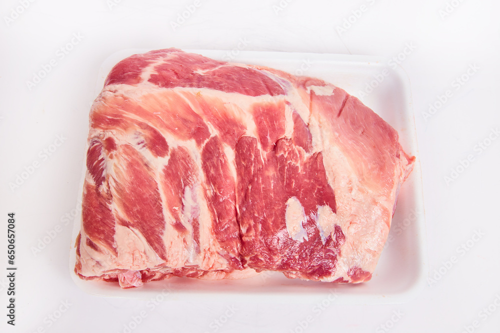 Fresh cut slab of raw pork rib meat in white tray on white background Fresh cut slab of raw pork rib meat in white tray on white background