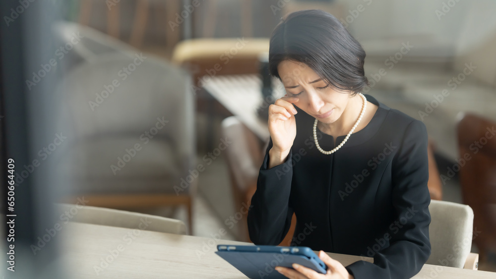 タブレットで思い出を見る女性 タブレットで思い出を見る女性