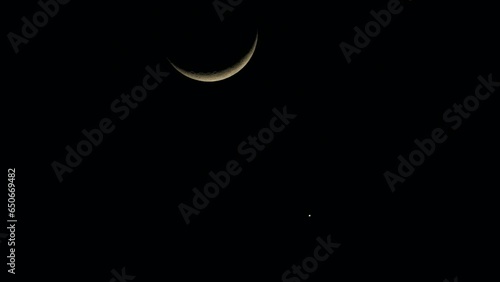 A new moon and a star are visible in the sky