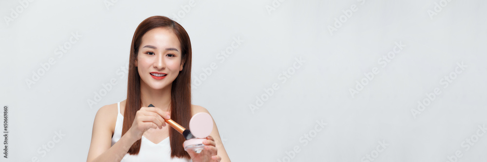 Glamorous beautiful female applying cushion powder for facial makeup concept on banner Glamorous beautiful female applying cushion powder for facial makeup concept on banner