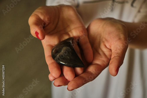 Woman Holding a different natural magic massage stones with both hands photo