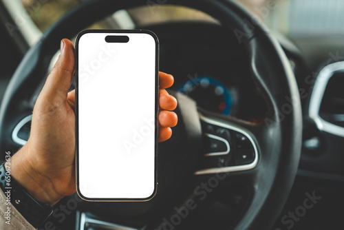 Fototapeta Naklejka Na Ścianę i Meble -  A phone with an isolated screen in the hands of a woman in a car