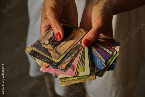 Tableau sur toile Red ornament metaphorical psychological asocial cards in hands with candles and branches of wheat