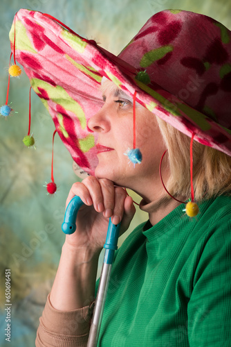 Clown in a hat. The buffoon grimaces and entertains. Portrait of a dressed up artist.