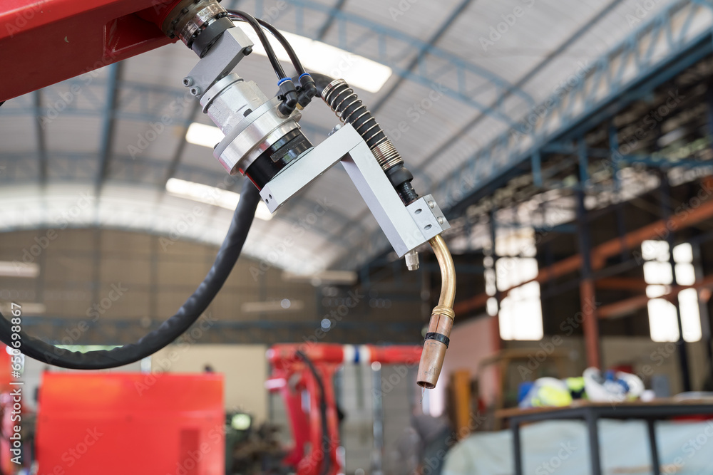 Robotic arm at production line in factory industrial. Automatic robot arm system welding machine in the industry factory. Industrial robot manufacturing technology Robotic arm at production line in factory industrial. Automatic robot arm system welding machine in the industry factory. Industrial robot manufacturing technology