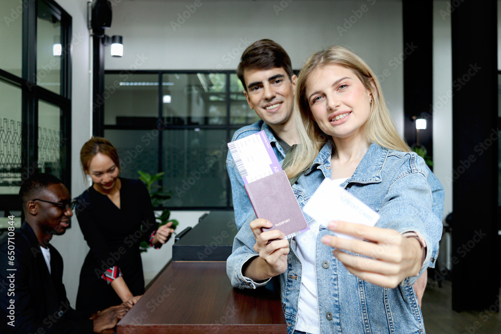 Beautiful woman traveler with long blonde hair shows credit card, holds ...
