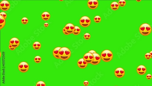 Emoji with heart shaped eyes. In love emoticon, yellow face with heart-eyes and open smile. Animated falling emojis. Social media icons symbol animation with green screen background.