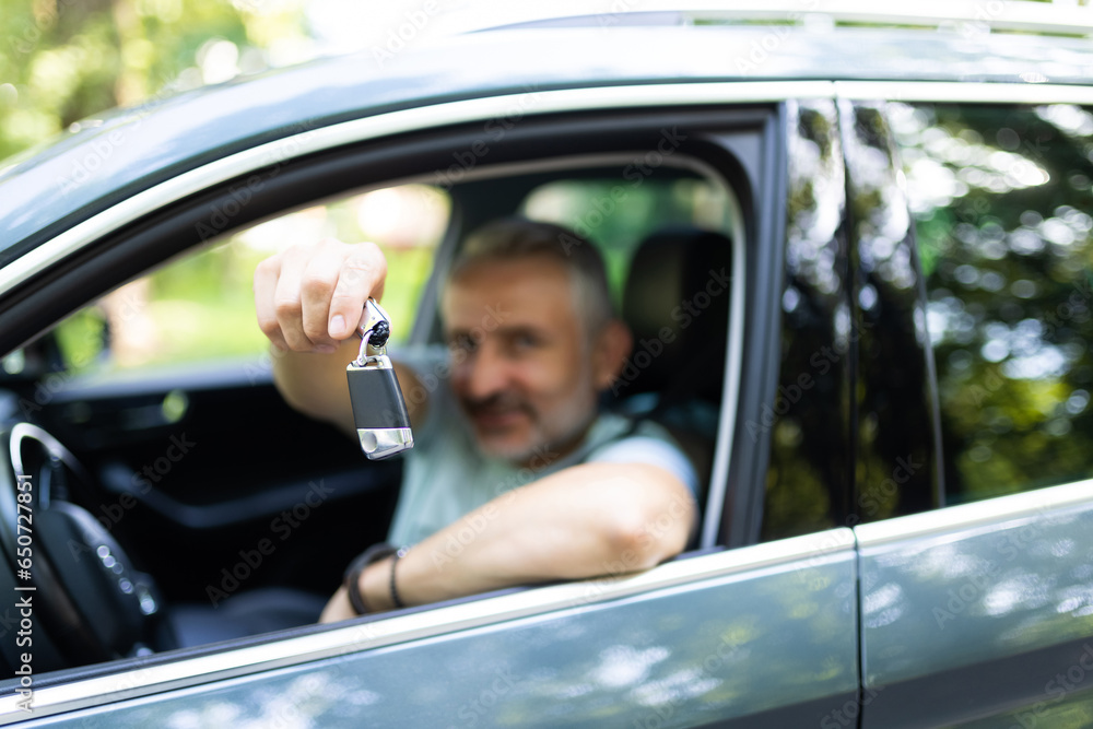 Middle age man smiling confident holding key of new car at street