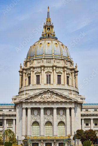Photography Close up of city hall entrance with focus on gilded dome and white pillars above