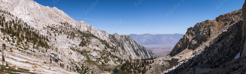 Panorama view of mountain valley with conifers and lake with white rocks around in Mount Whitney in usa