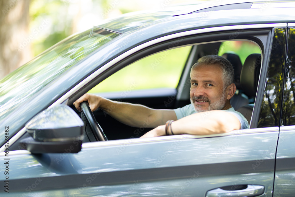 Portrait of senior man driving car on the road