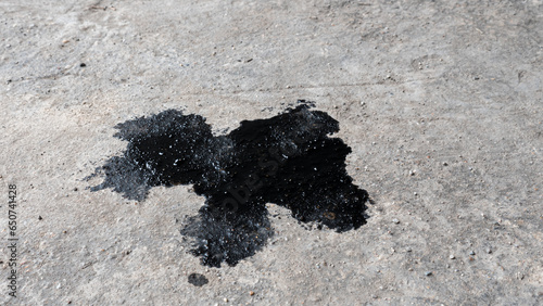 Abstract black engine oil drop on concrete floor texture backgruond.
Automobile garage dirty old oil stain cement pattern.  