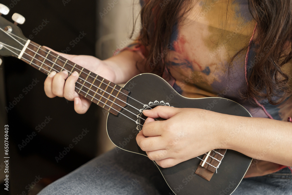 Woman playing ukulele cheerful girl learns to play at home