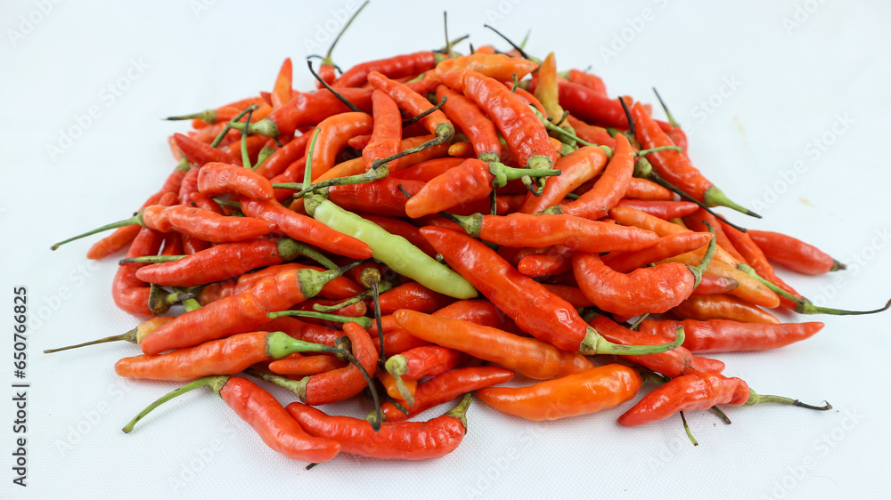 Big pile of chiili peppers in different colors, yellow, green and red, isolated on white