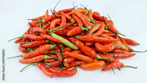 Big pile of chiili peppers in different colors, yellow, green and red, isolated on white