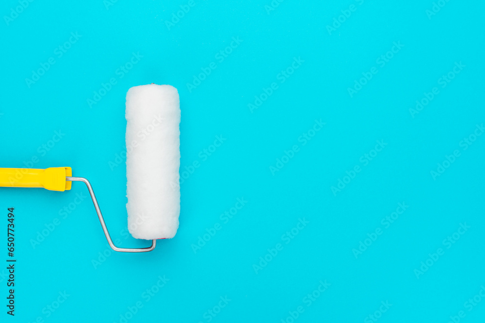 Obraz premium Clean paint roller on the turquoise blue background with copy space